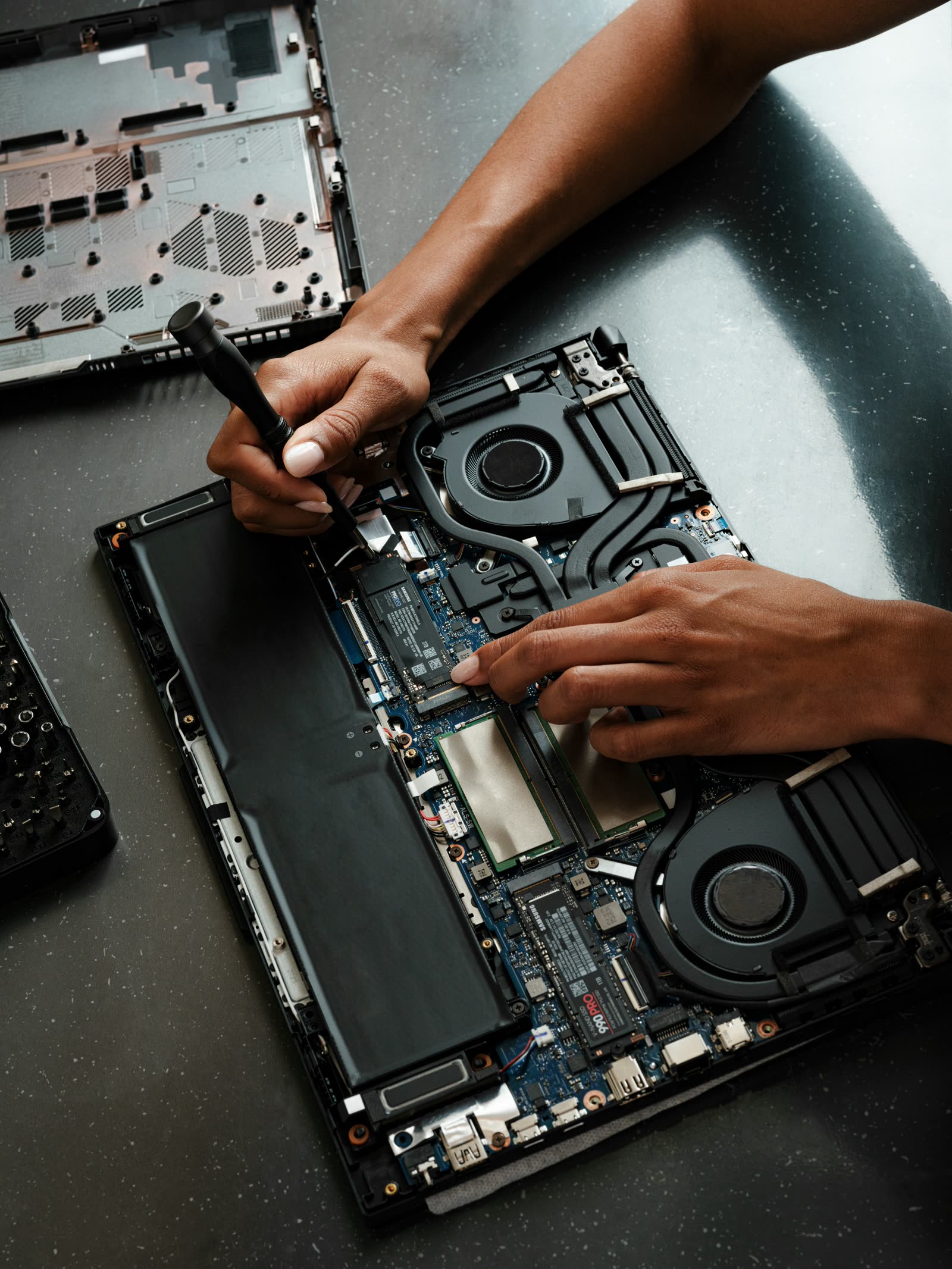 Yasir repairing a laptop at the workbench